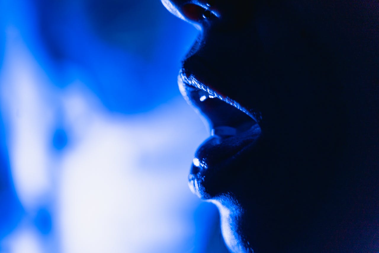 our-services-02 Close-up abstract image of an open mouth silhouette in dramatic blue lighting.
